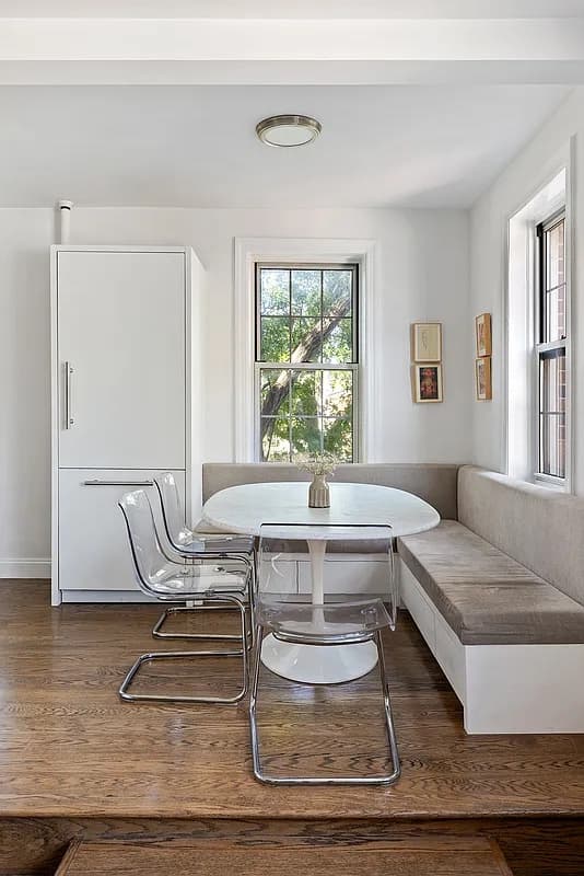 Kitchen banquette with a round marble table and acrylic chairs