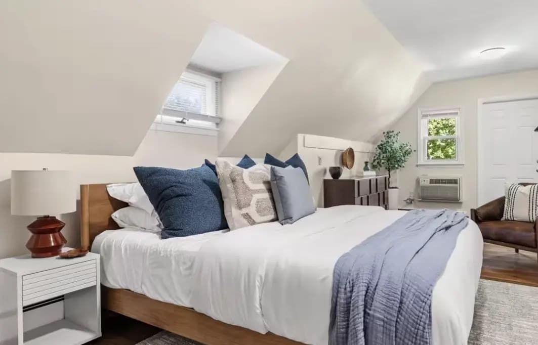 Primary bedroom with a wood-frame bed and blue accent pillows
